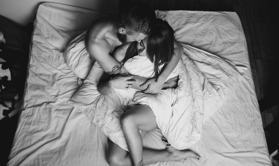 A man and woman cuddling in bed part of the blood and glamour blog post.