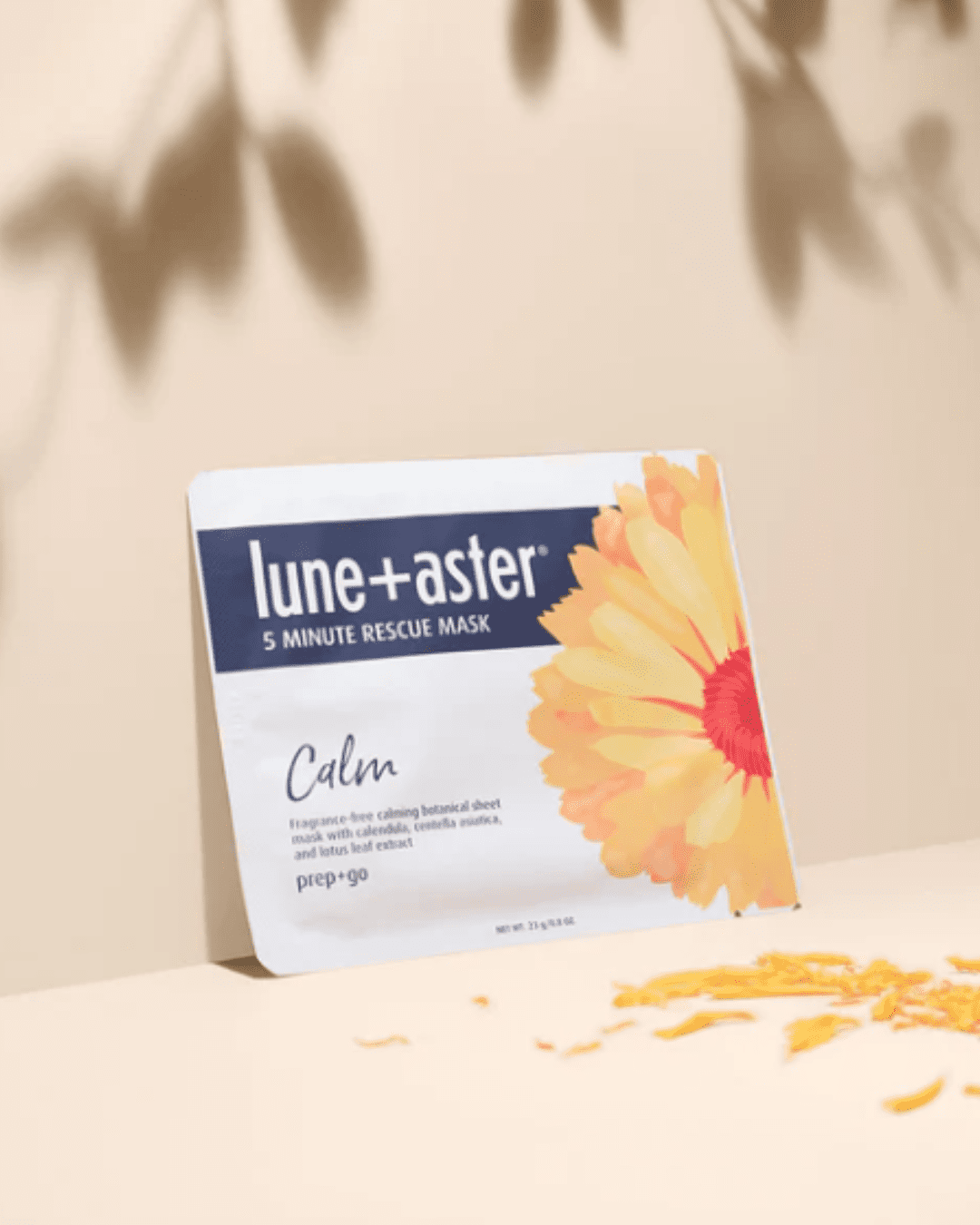 Lune + Aster 5 Minute Rescue Mask Calm leaning against a wall and petals by it on the surface it's leaning on, and this mask is part of a beauty routine.