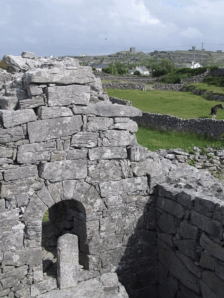St. Gobnait's Church on the island of Inisheer. The current church dates from the 11th century, but there are claims it was first founded by Gobnait herself, and that it contains the remains of her beehive hut. Photo Credit: Laurel Lodged (CC BY-SA 3.0 DEED)