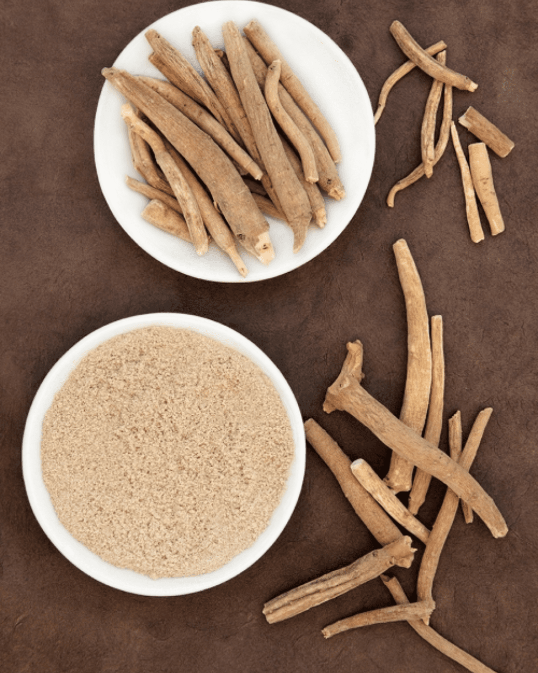 A flat-lay pf two white ceramic plates holding bundles of natural stick-like materials, with additional pieces scattered around, styled to evoke an earthy, holistic aesthetic.