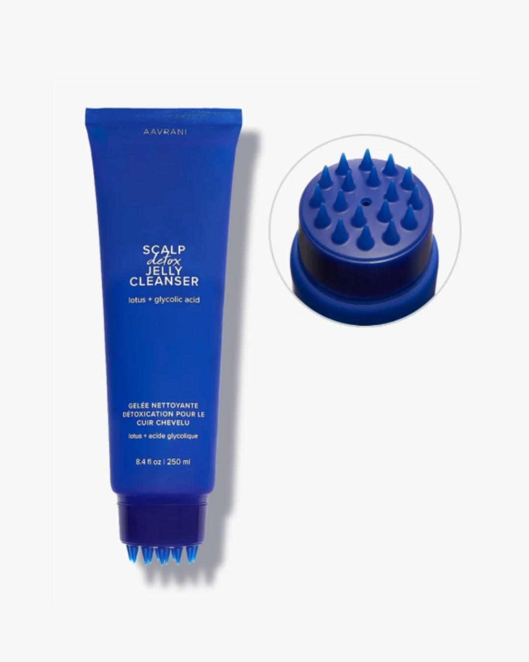 AAVRANI’s Scalp Detox Jelly Cleanser in a blue bottle with built-in scalp massage applicator, shown on a white-gray background with a close-up of the massage head in a circle.