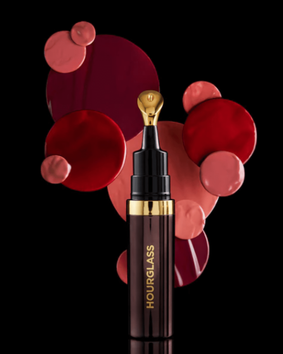 Hourglass No. 28 Lip Treatment Oil on a black background with different colored circle lipstick colors in a design in this fall self-care guide.