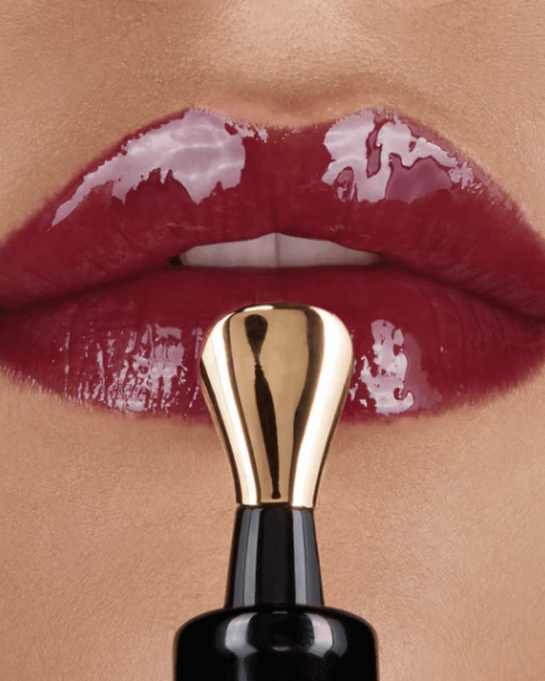 Hourglass No. 28 Lip Treatment Oil resting on a woman's lips that has this lipstick applied to her lips in this fall self-care guide.