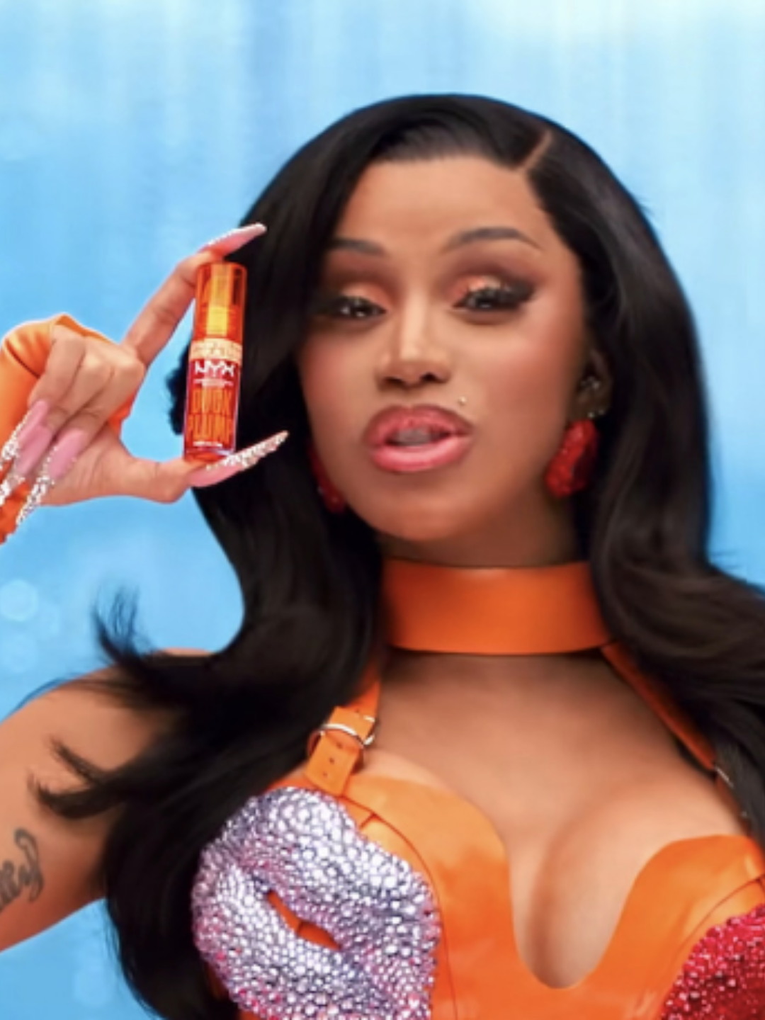 Cardi B holding NYX Professional Makeup Duck Plump High Pigment Lip Plumping Gloss.