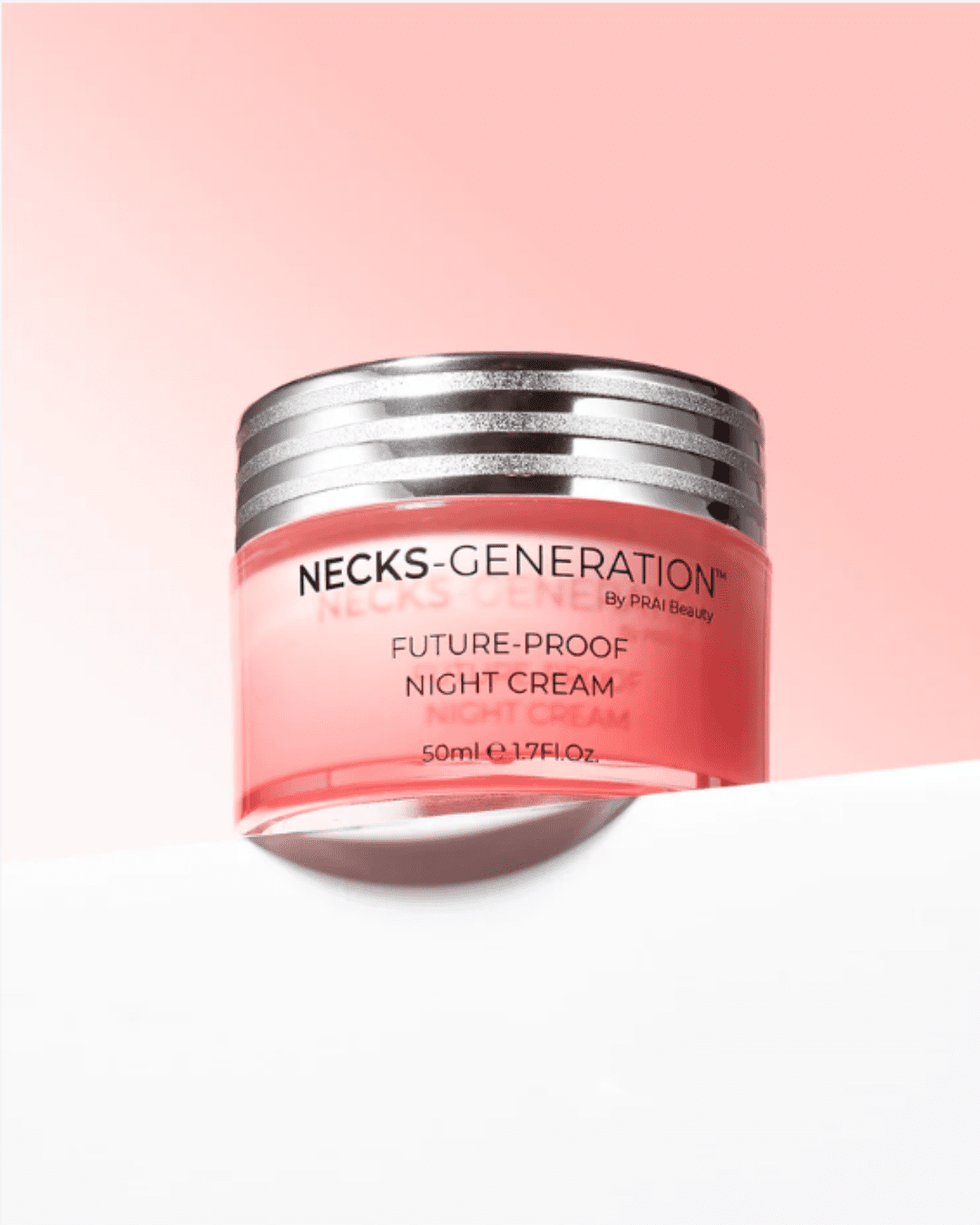 PRAI Beauty Necks-Generation Future-Proof Night Cream on a white surface with a light pink to white gradient background, product slightly over the edge of the surface.