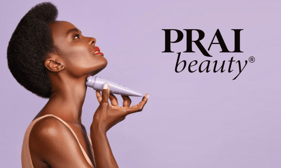 Black woman applying PRAI Beauty neck product to her neck, facing sideways and looking up, with a light purple background featuring the PRAI Beauty logo.