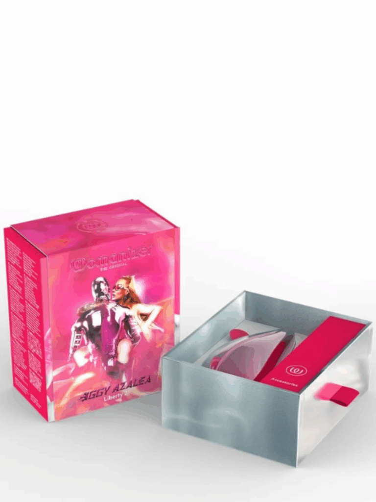 Womanizer and Iggy Azalea collaboration Pink Liberty 2 sex toy. Iggy Azalea posing with a pink humanoid male robot with her arms and legs wrapped around him as if they are being intimate on the pink box cover. The silver bottom compartment opens to reveal the metallic pink device, charger, and accessories. The metallic pink box design symbolizes female empowerment, self-love, and luxury pleasure.