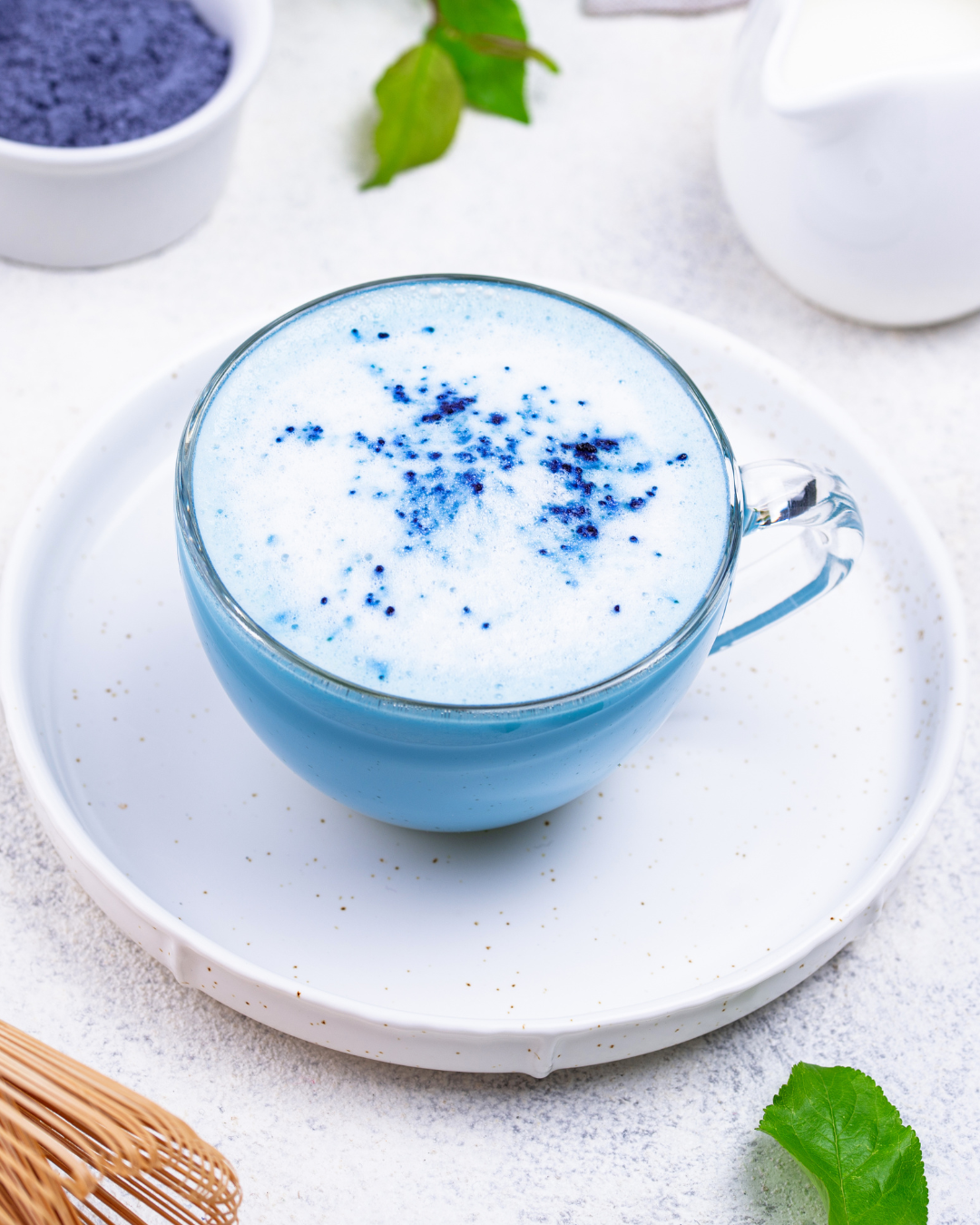 Blue Matcha in a mug on a white saucer.