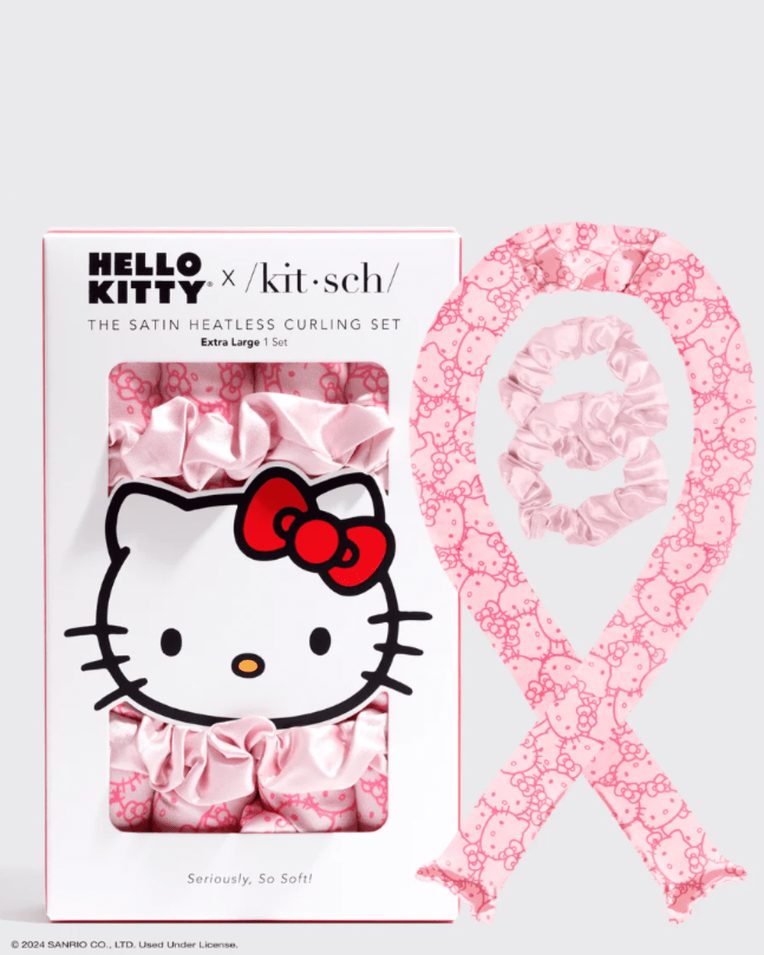 Packaging of Kitsch Hello Kitty Heatless Curling Set next to the curling product removed from the box, showing the two pink scrunchies inside the loop the curler makes.
