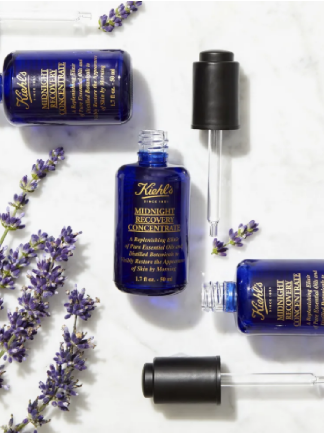 Kiehl’s Midnight Recovery Concentrate bottles surrounded by lavender plants.