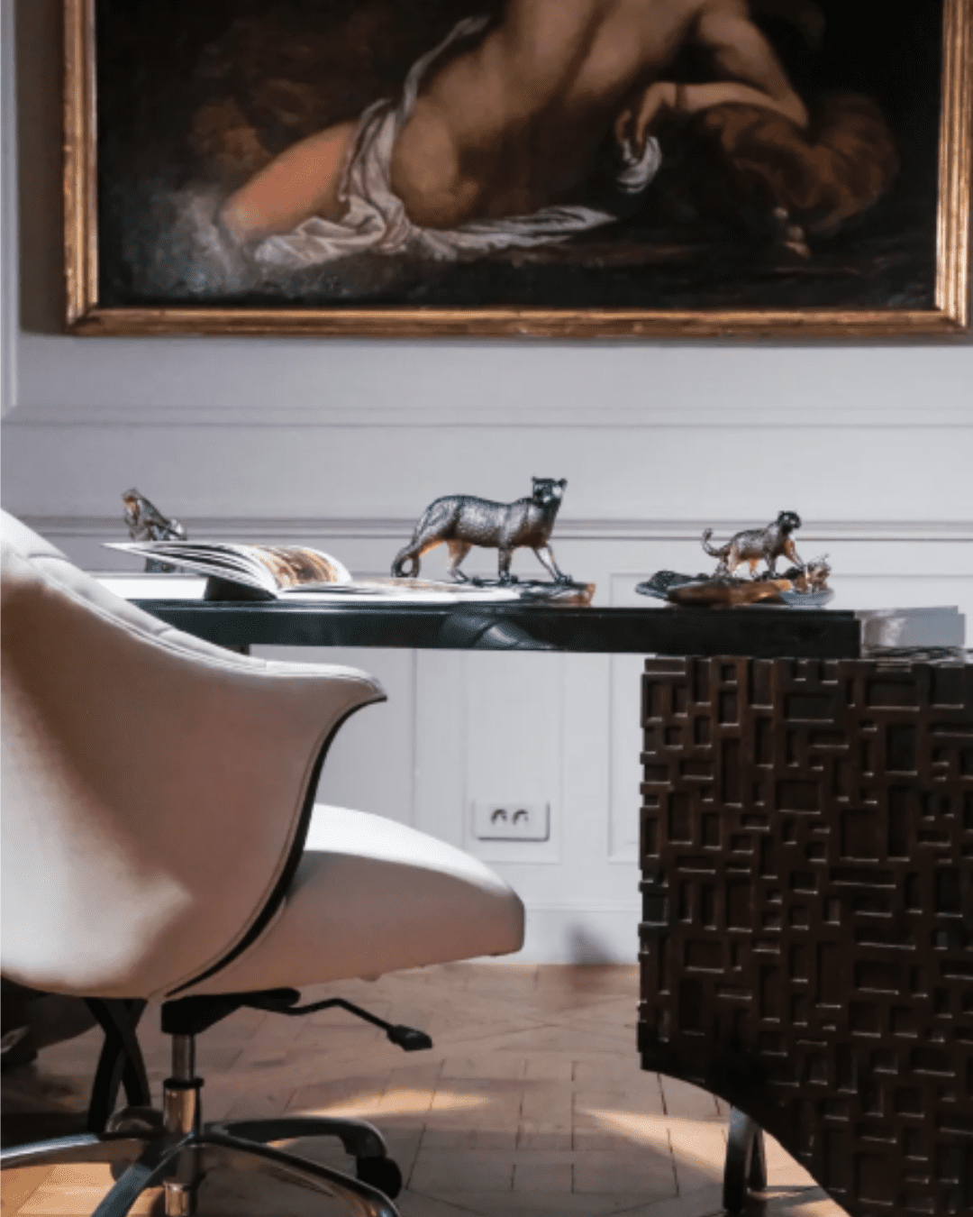 Daum Leopard Pen Holder displayed on desk with white chair and Renaissance-style painting in the background.