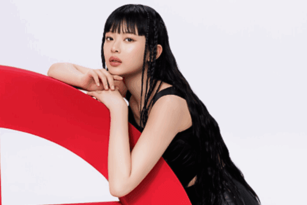 Hanni from NewJeans leaning on Giorgio Armani logo for Armani Beauty collaboration feature image.