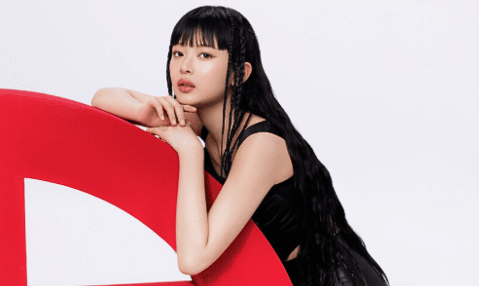 Hanni from NewJeans leaning on Giorgio Armani logo for Armani Beauty collaboration feature image.