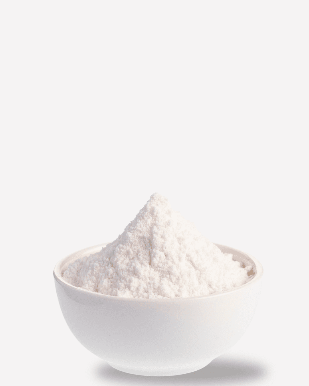 White bowl filled with baking soda on a white surface, representing the ingredient that shouldn't be used in skincare and that fruit-based skincare is much safer for your skin.
