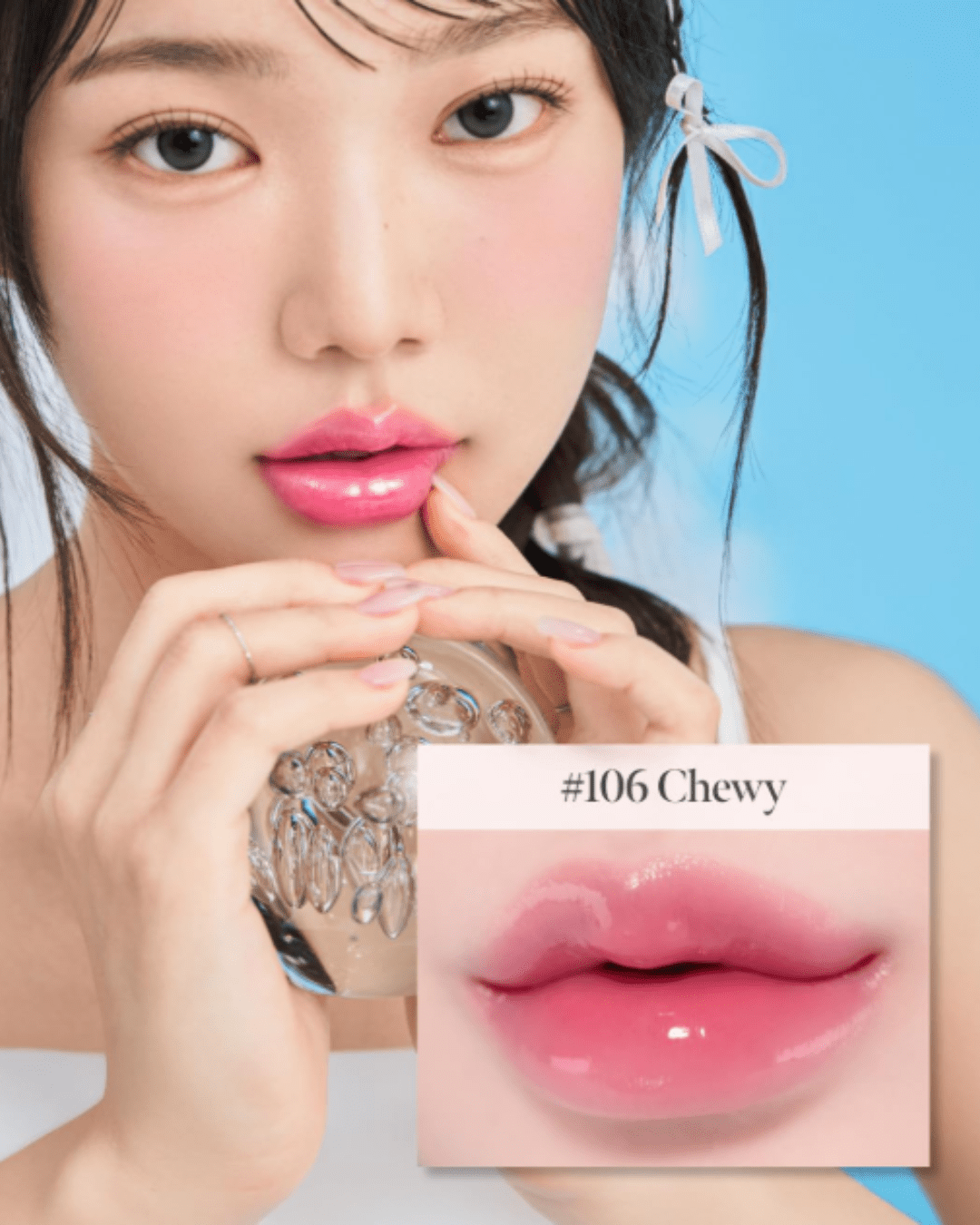 Asian girl against a blue background holding a clear crystal ball with air bubbles, wearing a white ribbon in her hair, white tank top, and Coral Haze Glow Lock Jelly Tint shade 106 Chewy on her lips. A close-up box shows her lips with a text "106 Chewy". Perfect for highlighting beauty as a self-love practice.