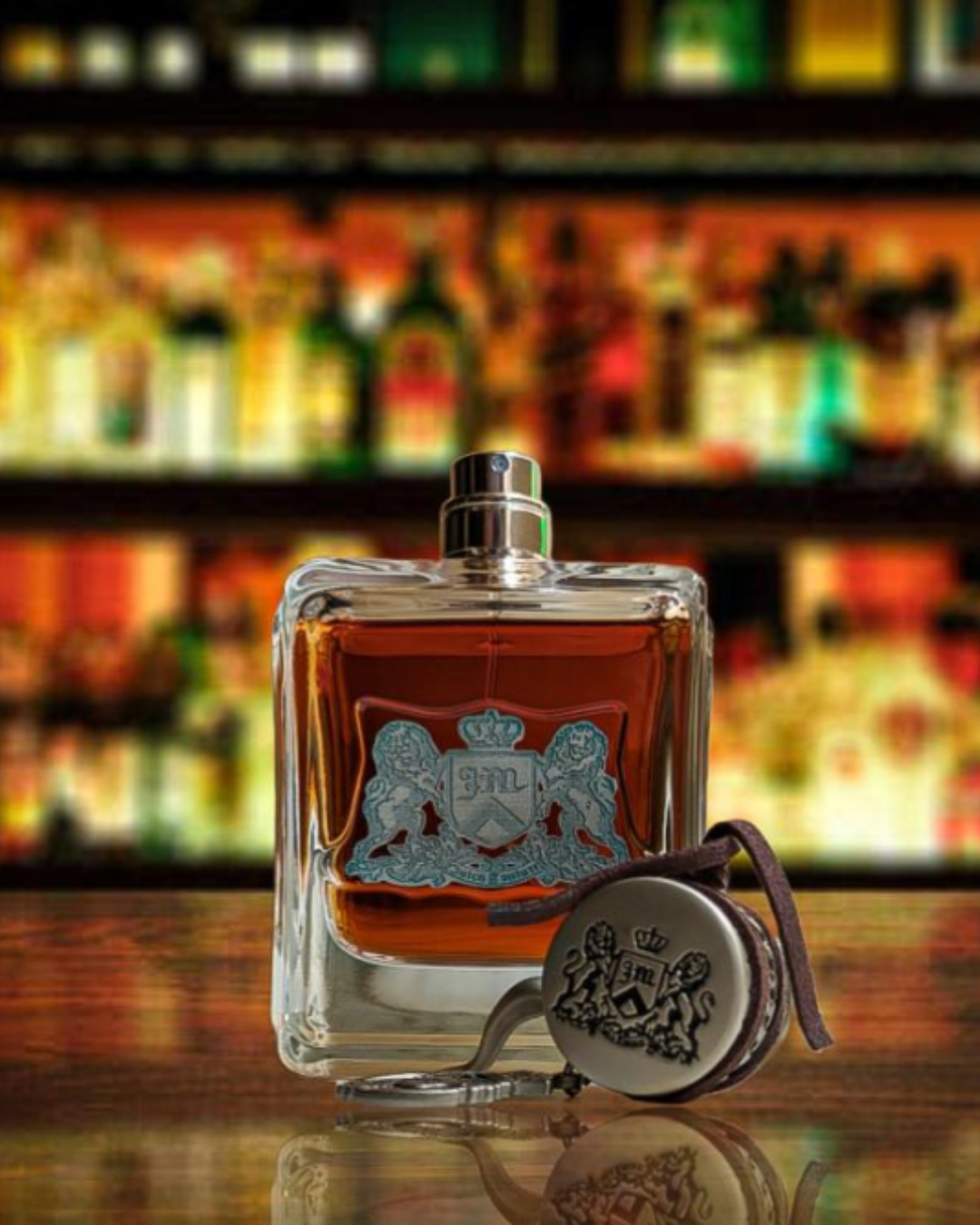Juicy Couture Dirty English on a bar top with alcohol behind it.
