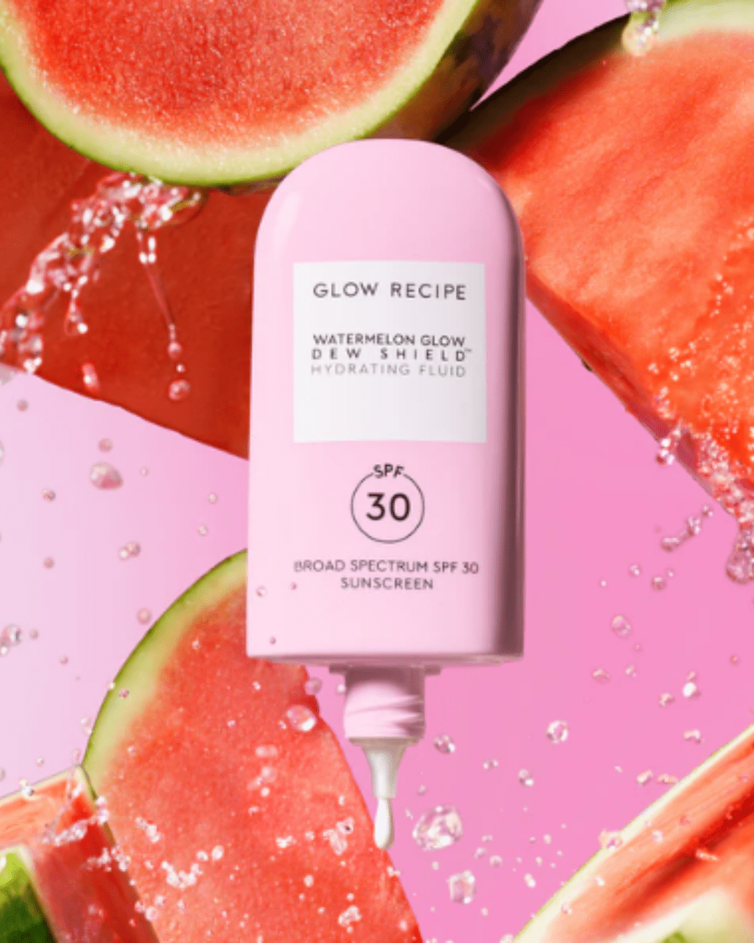 Glow Recipe Watermelon Glow Dew Shield SPF 30 with cap off, sunscreen oozing out, surrounded by watermelon slices and splashing water, suitable for acne.