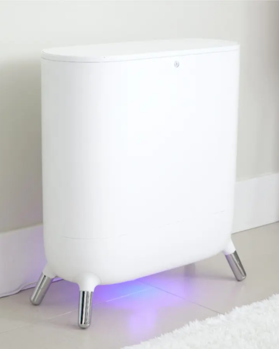 Sharper Image Spa Studio Towel Warmer on a bathroom floor with angled silver feet and blue-purple LED light, warming towels as part of a relaxing self-love practice.