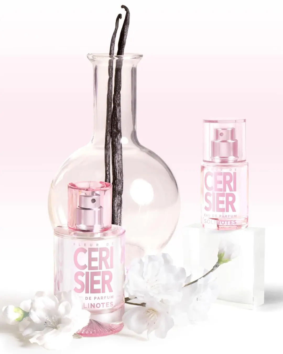 Cherry Blossom Eau de Parfum by SOLINOTES styled with a clear vase filled with vanilla beans and white flowers surrounding the perfume bottle, highlighting the floral sweetness of cupcake-inspired perfumes.