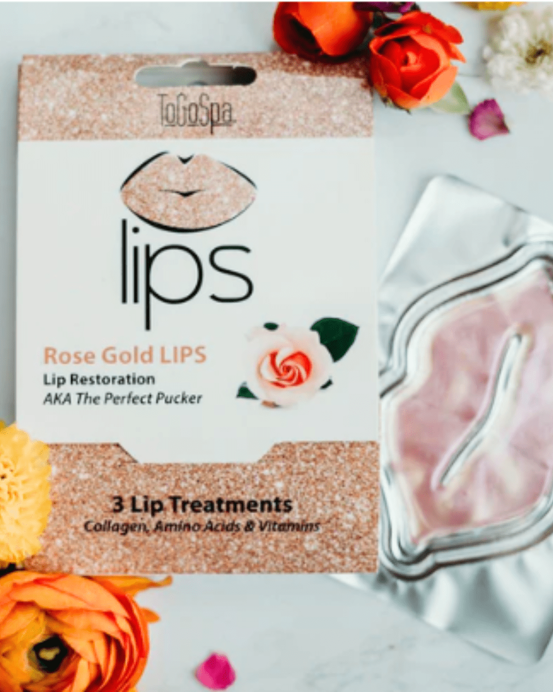 To Go Spa Rose Gold LIPS The Perfect Pucker mask package with sealed mask displayed beside it, surrounded by orange-yellow flowers on a white surface.