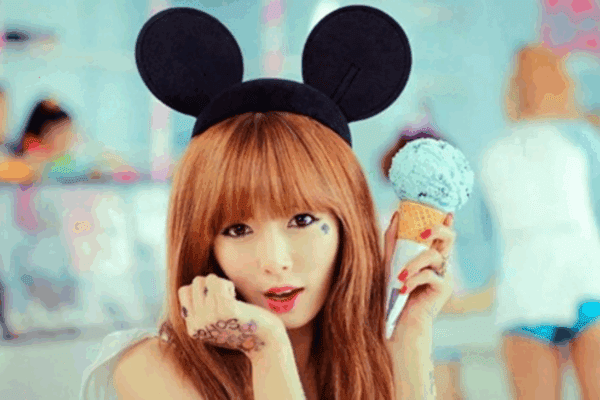 Hyuna from her "Ice Cream" music video holding ice cream in her hand while wearing Mickey Mouse ears, a playful inspiration for ice cream perfumes.