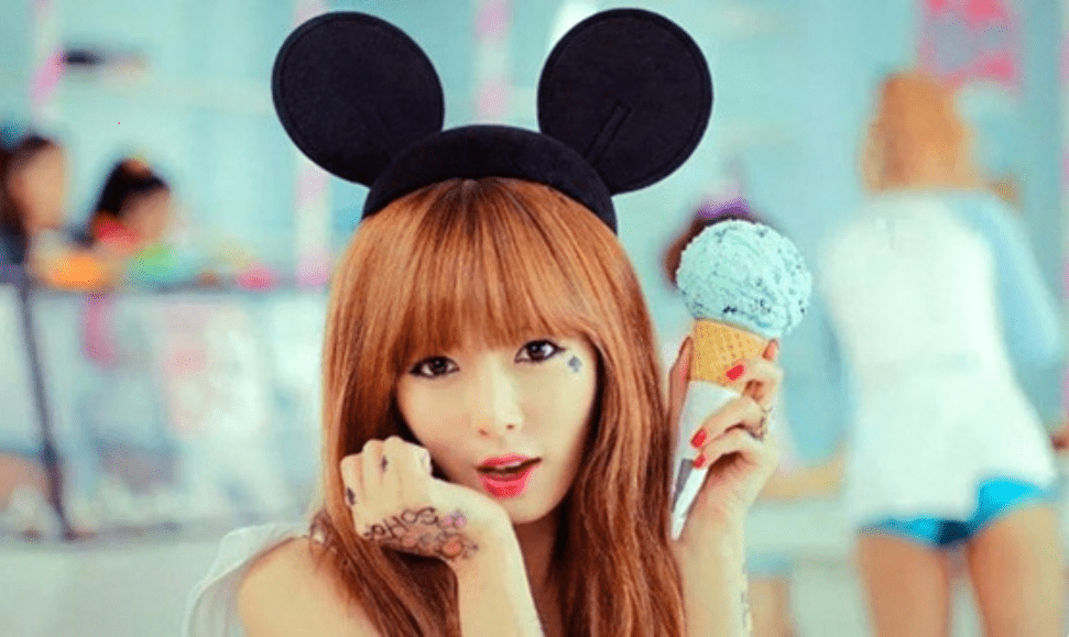 Hyuna from her "Ice Cream" music video holding ice cream in her hand while wearing Mickey Mouse ears, a playful inspiration for ice cream perfumes.