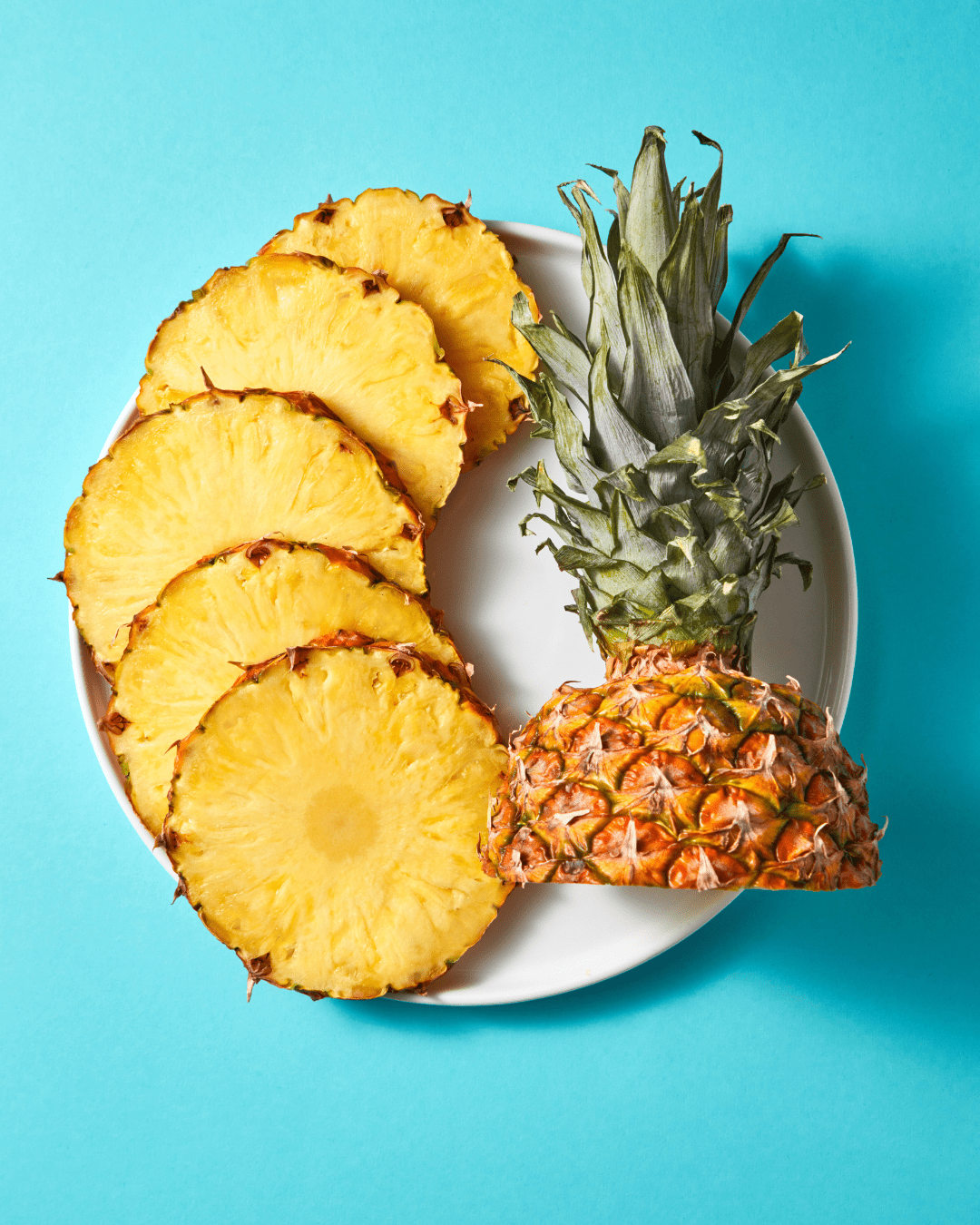 Pineapple slices and the pineapple head on a plate