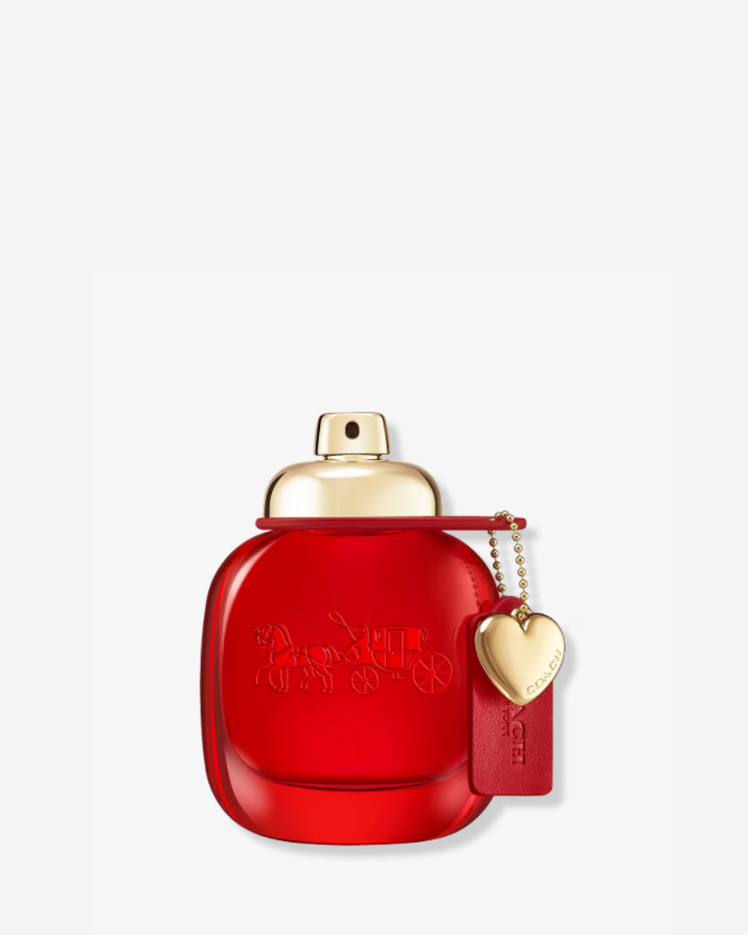 Coach Love Eau de Parfum bottle with a heart shaped locket charm and Coach tag, photographed against a white background, exemplifying fruity strawberry perfumes.
