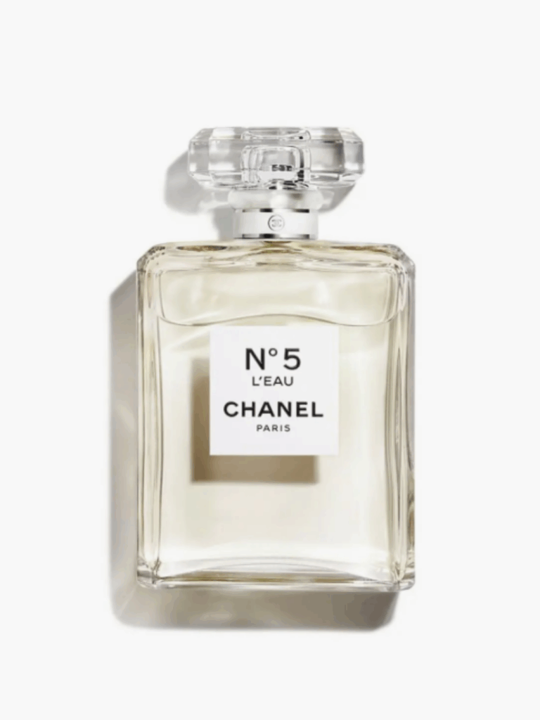 Chanel No. 5 L'EAU perfume bottle lying flat on a white surface, filled with the fragrance, displaying the Number 5 L'EAU Chanel Paris label clearly.