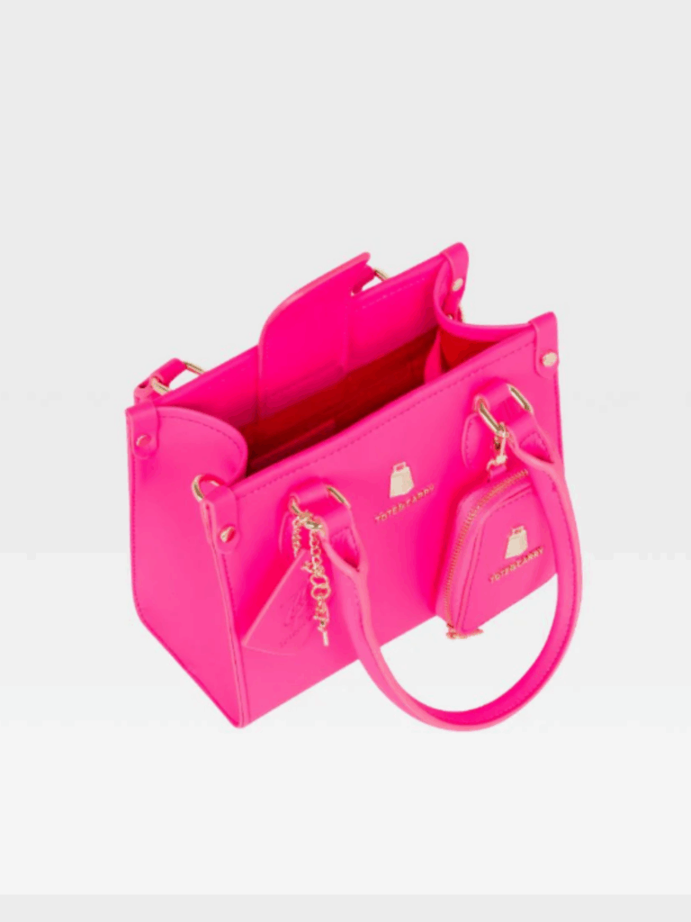 Tote N Carry Lisse Mini Tote Bag in neon pink shown with handles folded downward on a white surface. The open top reveals interior space ideal for storing small items such as a hand sanitizer and coin purse.