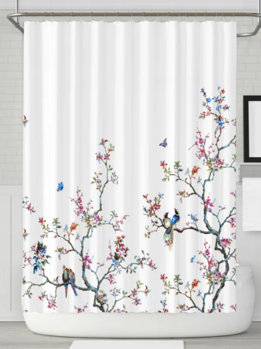 A white shower curtain with branches and little birds sitting on them.