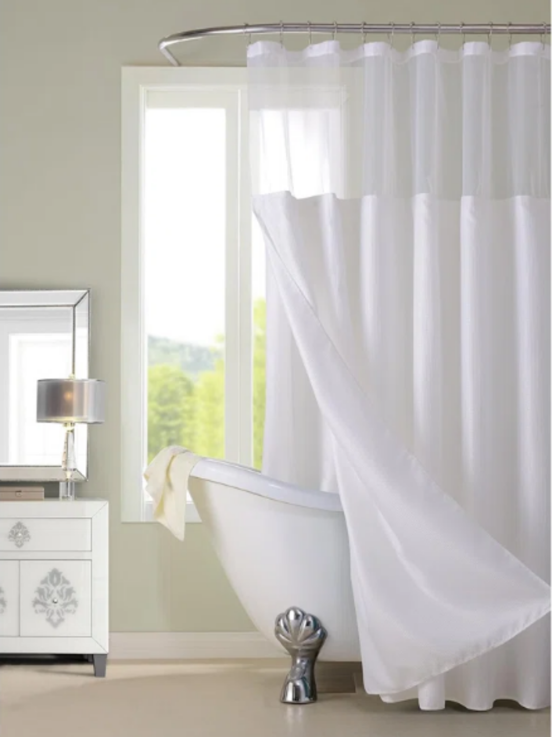 A soft white shower curtain that works great for a bath and shower combination.