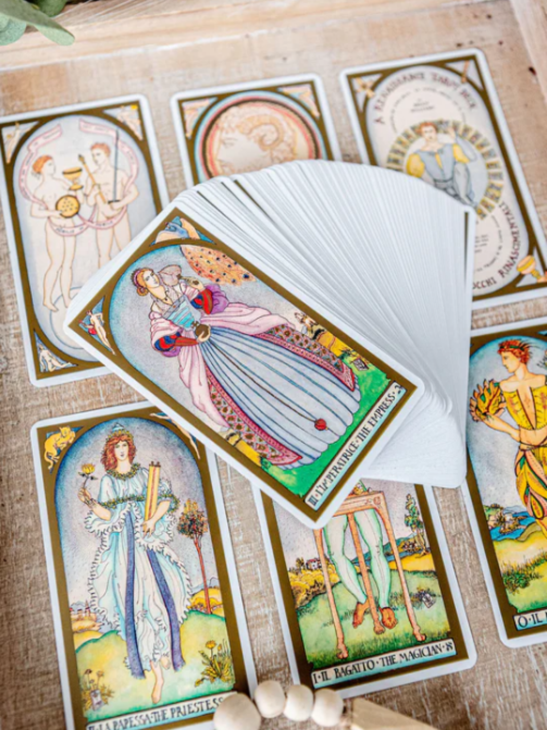 Six-card spread from the Renaissance Taro with the rest of the deck fanned beside it, showing detailed Renaissance illustrations and muted summer hues. The layout highlights the deck's symbolic depth and visually complements the Strawberry Moon's themes of clarity, growth, and early-summer intention setting.