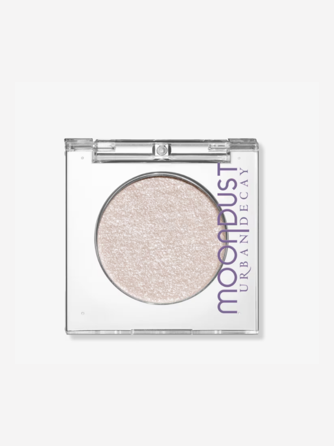 Urban Decay 24/7 Moondust Glitter Eyeshadow single photographed in its clear plastic compact on an off-white surface, showcasing the shade and beauty packaging.