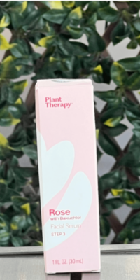 Plant Therapy Rose with Bakuchiol Facial Serum in light pink packaging with a white floral design, labeled Step 3, displayed on an outdoor table with lattice and ivy leaves in the background.