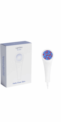 LightStim for Acne product display on a white background. The image shows the white box with a gray blue lid, text on the front reading "Hello Clear Skin', and a partial side view with the text "Restore Your Skin's Clear and Healthy Appearance". Next to the box is the white LightStim for Acne device, with the circular light area showing mostly blue light with some red dots.