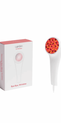 LightStim for Wrinkles product display on a white background. The image shows the white box with a red top featuring a picture of the device and the text "Bye-Bye Wrinkles" on the front, a partial side view with the text "Maintain Your Skin's Youthful Appearance", and the LightStim device itself, with the circular red light therapy area glowing with red and yellow tones.